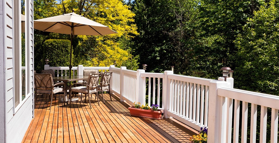 Holzterrasse mit Tisch und Stühlen